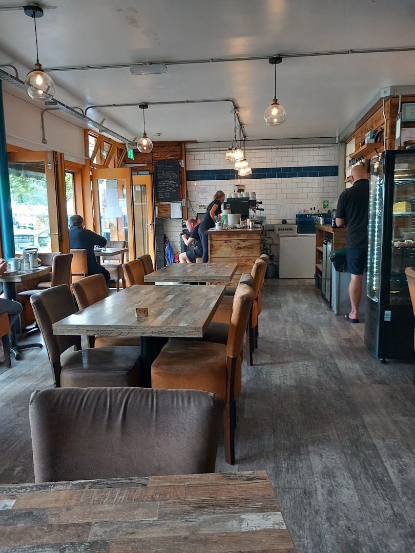 Inside Brunch: wooden tables and brown leather chairs, pendant lights, white tiles and the coffee counter at the back
